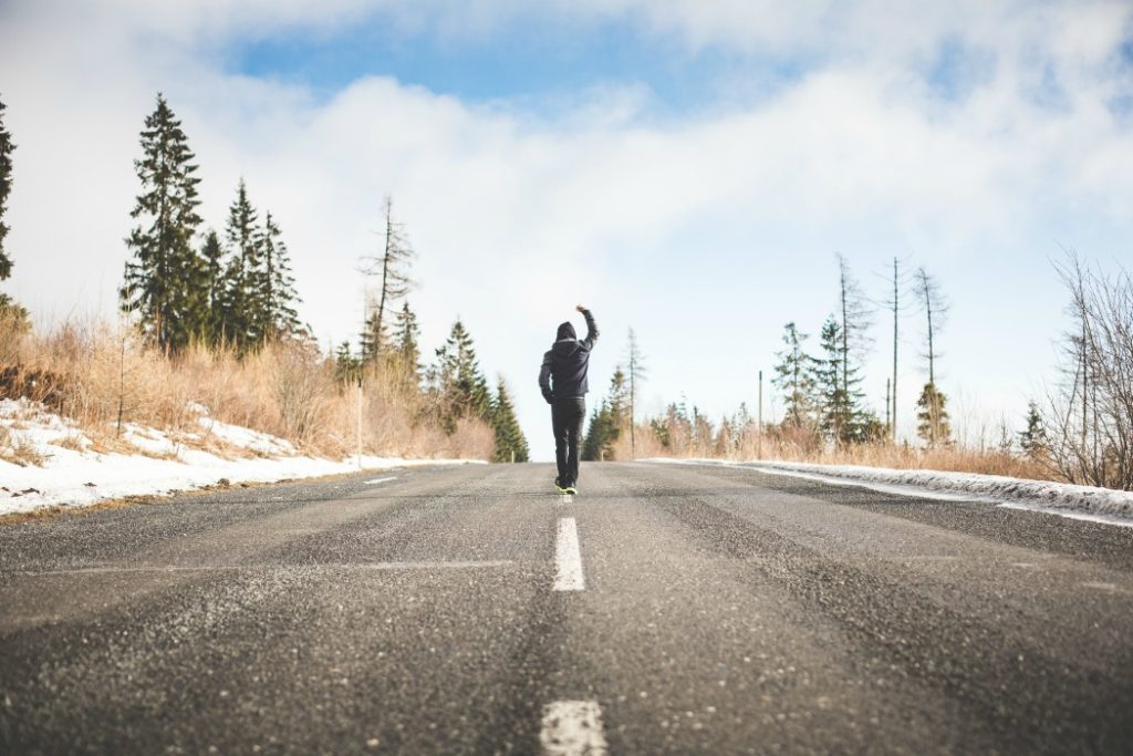 man in a winner pose walking on the road picjumbo com
